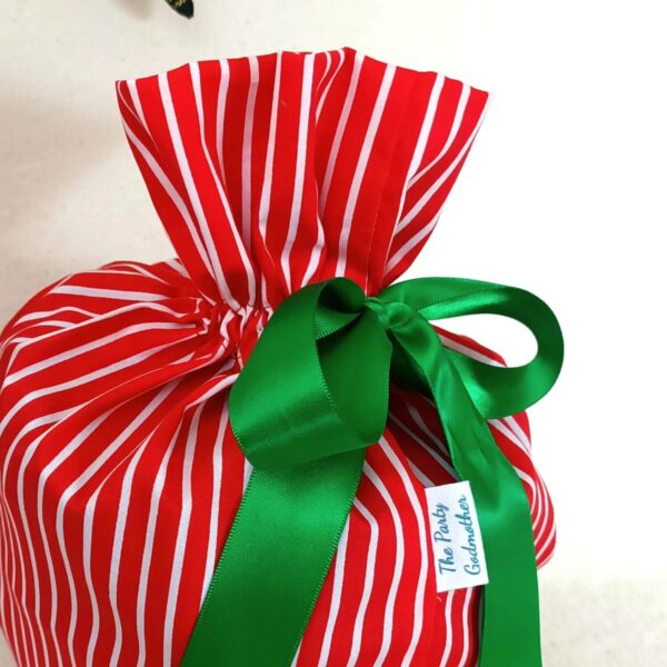 Red stripe reusable fabric gift bag. The Party Godmother Christmas party supplies.